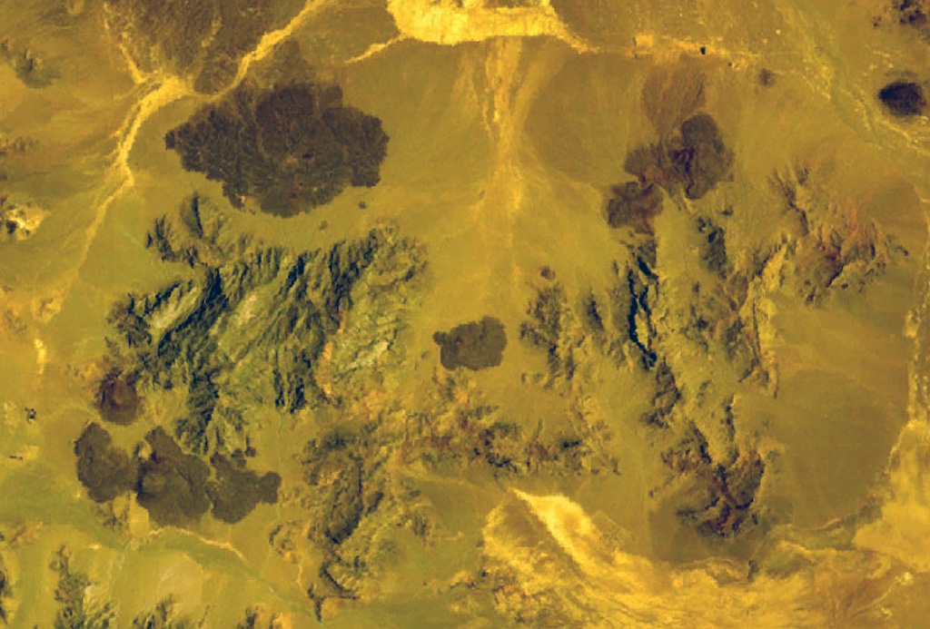 Quaternary basaltic lava flows are visible in this NASA Landsat image (N to the top) of SE Iran. The lava flows are part of unnamed volcanic field between Taftan and Bazman volcanoes. Preserved cones and craters were erupted among a group of Cretaceous limestone peaks. NASA Landsat 7 image (worldwind.arc.nasa.gov)