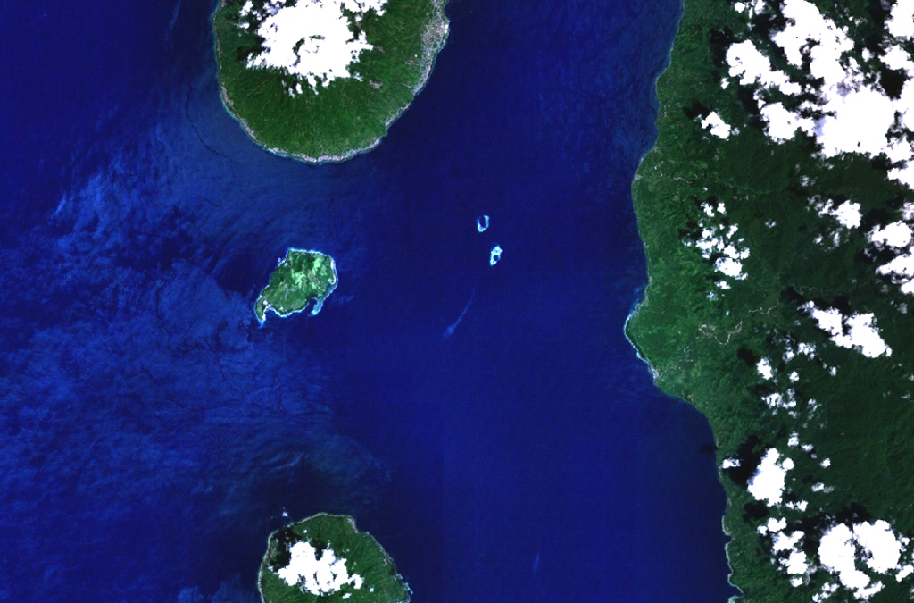 The small island of Mare (left-center) lies between Tidore (top-center) and Moti (bottom-center) volcanoes in this NASA Landsat image (with north to the top).  Mare is one of a chain of volcanic islands off the western coast of Halmahera Island (right).  The 2 x 3 km island is elongated in a NE-SW direction, and a large breached crater is located off the SW tip of the island.   NASA Landsat 7 image (worldwind.arc.nasa.gov)