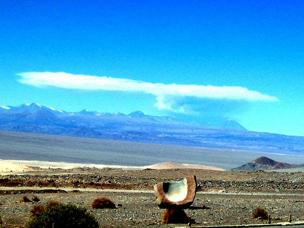 An eruption plume rises above Lascar on 18 April 2006 as photographed from El Abra copper mine, 220 km NW. The plume rose a maximum height of about 10 km.  Intermittent ash eruptions continued until July 2007. Image courtesy of employees at the El Abra copper mine, 2006.