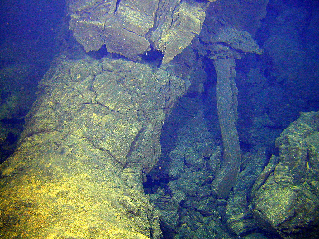 Two submarine volcanoes, known informally as Volcano W, were discovered during a New Zealand-American mapping expedition in 2004. This view taken at the SE volcano from a submersible vehicle during a 2005 expedition shows lava extruding from a tube before it solidified in place. The SE volcano rises to within about 900 m of the sea surface and contains a cone in its summit caldera. Image courtesy of New Zealand-American Submarine Ring of Fire 2005 Exploration, NOAA Vents Program.