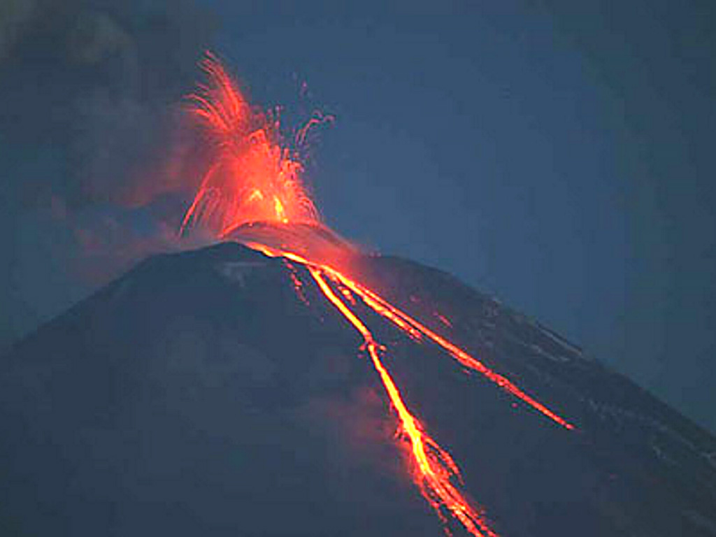 Incandescent Strombolian ejecta rises above a new scoria cone in the summit crater of Klyuchevskoy volcano on 22 May 2007. Lava flows travel down the NW flank. Strombolian eruptions had begun on 15 February 2007, and explosive activity and lava effusion continued until 15 July. Photo by Yu. Demyanchuk, 2007 (KVERT).