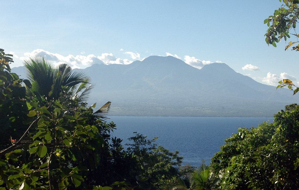 The broad Cuernos de Negros volcanic complex is seen here from the small island of Apo, 7 km SE of the city of Zamboanguita at the southern end of Negros Island. The eastern side of the complex consists of two cones and a lava dome with two crater lakes up to 1.5 km in diameter. The small summit crater of Magaso, the highest peak of the complex, rises above the city of Dumaguete and contains fumaroles. The Palinpinon geothermal field is located on the north side of the volcano. Photo by Arne Kuilman, 2007.