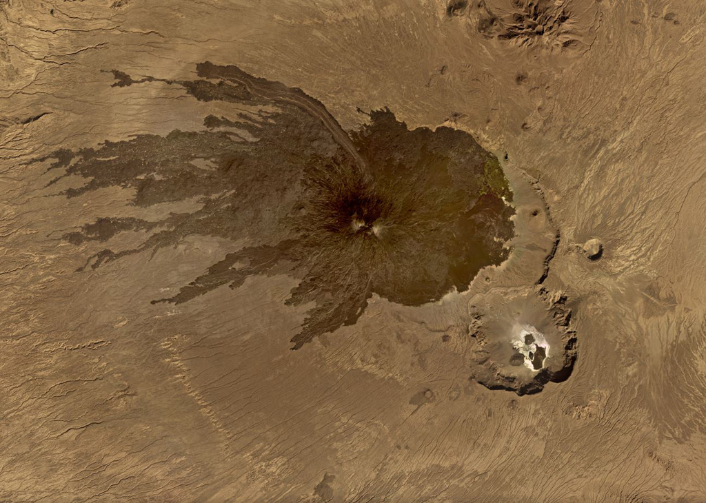 Tarso Toussidé is a nested caldera system in the Tibesti massif in Chad, seen in this November 2019 Planet Labs satellite image monthly mosaic (N is at the top; this image is approximately 44 km across). Trou au Natron is the caldera along the SE boundary, the crater to the NNE is Petit Trou/Doon Kidimi. The long, narrow lava flow to the NW is one of the more recent eruptive products. Satellite image courtesy of Planet Labs Inc., 2019 (https://www.planet.com/).