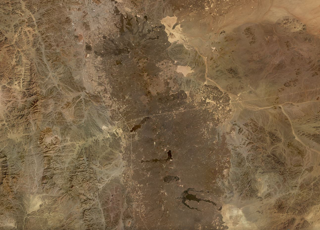 The northern part of the 20,000 km2 Harrat Rahat volcanic field, the largest in Saudia Arabia at 50-75 km wide and ~300 km long, is shown in this November 2019 Planet Labs satellite image monthly mosaic (N is at the top; this image is approximately 192 km across). Earlier work identified 986 vents across the field. Recent lava flows in the northern end encroach on the city of Al-Madinah. Satellite image courtesy of Planet Labs Inc., 2019 (https://www.planet.com/).