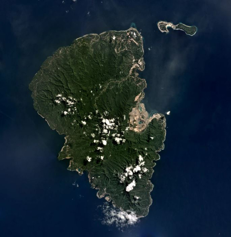 The 192 km2 Lihir Island, approximately 22 km long in the N-S direction, is shown in this July 2019 Planet Labs satellite image monthly mosaic (N is at the top). The Ladolam gold deposit open pit mine is visible on the E coast within the remains of Luise volcano that has undergone flank collapse, resulting in a 1-km-long debris avalanche deposit offshore. After the collapse event the gold deposit accumulated from hydrothermal fluids. Satellite image courtesy of Planet Labs Inc., 2019 (https://www.planet.com/).