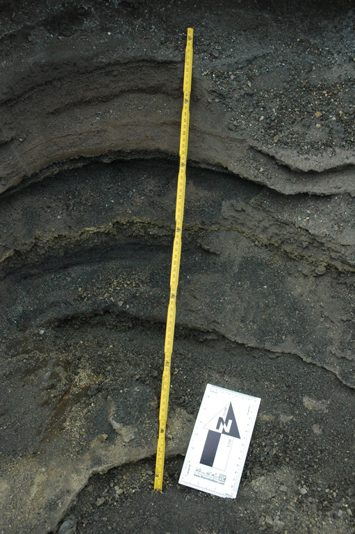 This outcrop within a barranca (ravine) on the western side of the Santa Ana summit area shows explosive deposits from the 2005, 1904, and older eruptions. The different ash and lapilli units have variable grain sizes, an indication of variations in explosivity. The yellow ruler is 72 cm long; photo taken in 2011. Photo by Lis Gallant, 2011.