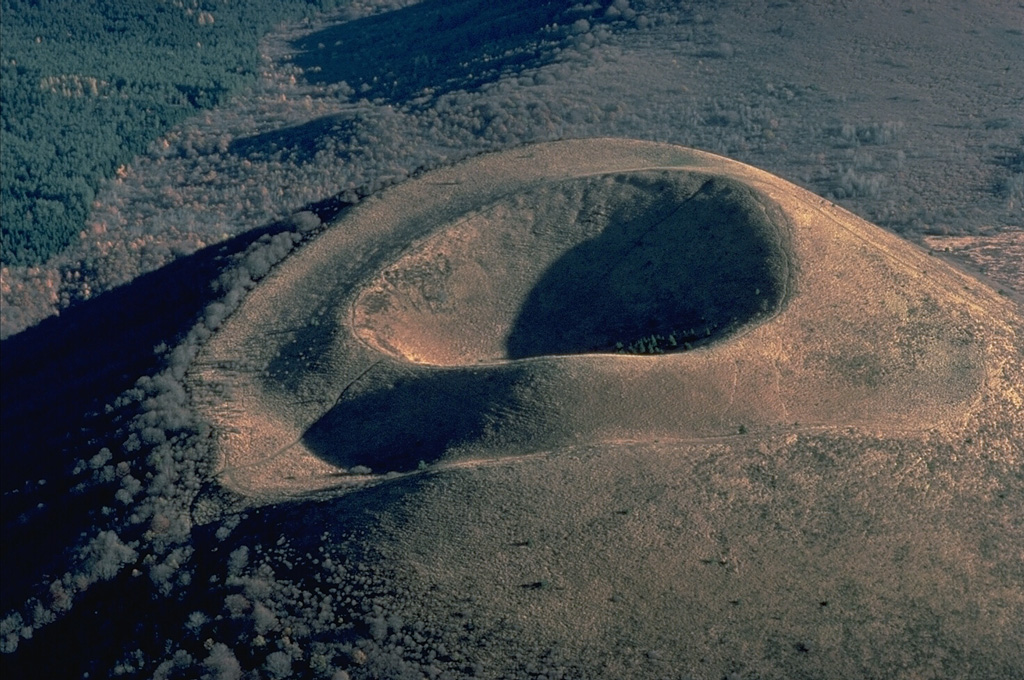 Puy de Côme, in the France's Chaîne des Puys volcanic field, is a beautiful example of a nested pair of craters.  The symmetrical crater at the summit of the cinder cone was formed by late-stage eruptions that built the small cone inside a larger crater rim produced by older eruptions. Copyrighted photo by Katia and Maurice Krafft.