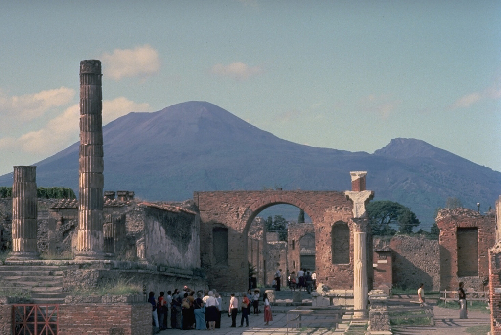 Mount Vesuvius rises to the north of the storied ruins of Pompeii, which was destroyed during the eruption of 79 CE.  The modern cone of Vesuvius rises at the left; the peak to the right is the rim of the Monte Somma caldera, which was formed about 17,000 years ago.  Eight major explosive eruptions have occurred since then.  A period of long-term eruptive activity began in 1631.  The last eruption of Vesuvius was in 1944. Copyrighted photo by Katia and Maurice Krafft.