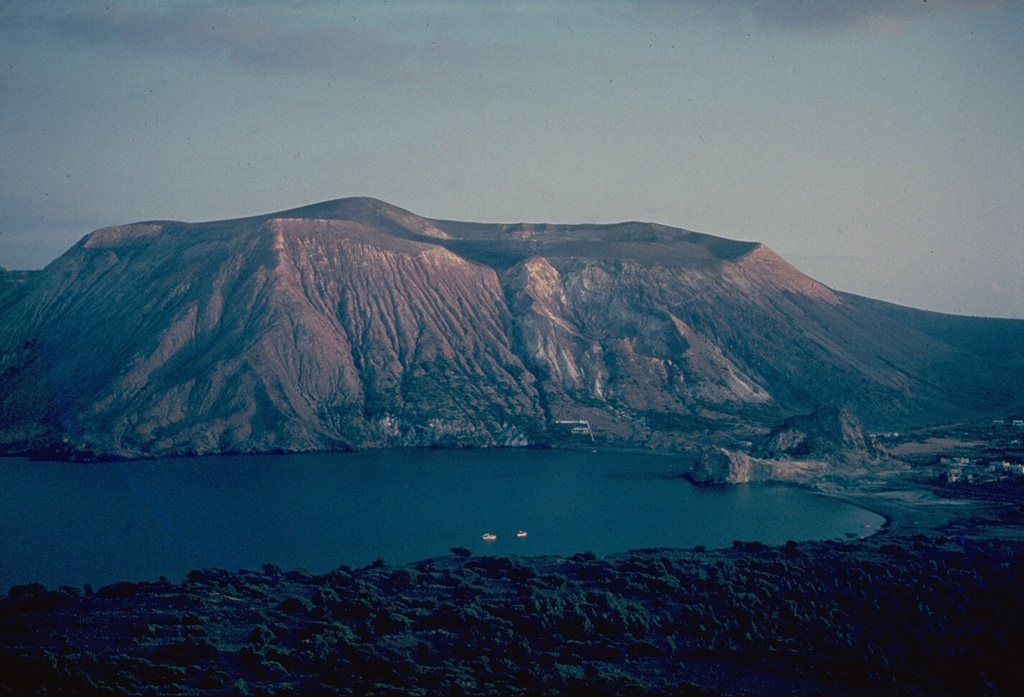 Fossa volcano, seen here from the small cone of Vulcanello to its north, is a 390-m-high tuff cone capped by a 500-m-wide crater.  Like tuff rings, tuff cones form as a result of explosive eruptions involving water-magma interaction, but can be less violent, allowing volcanic ejecta to accumulate around the vent, thus forming smaller diameter, steep-sided cones. Copyrighted photo by Katia and Maurice Krafft.