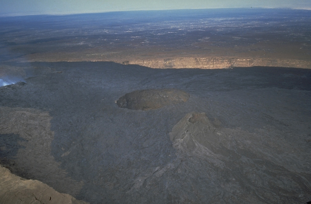This 1992 view looks S over the summit crater of Erta Ale. A pit crater at the center contains an active lava lake, not visible from this view. Overflows of lava from this crater during 1971-73 diverged around an older cone and covered much of the broad crater floor. Photo by Luigi Cantamessa, 1992 (courtesy of Pierre Vetsch).
