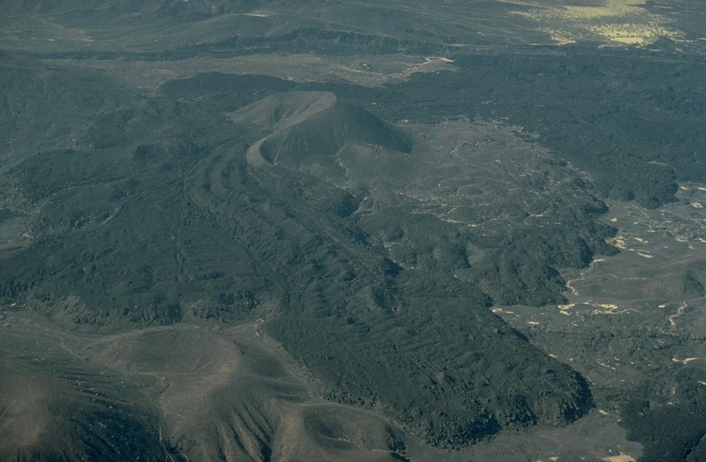 A lava flow with prominent flow levees issued from a breached cinder cone in the Mousa Alli volcanic complex.  This large Holocene stratovolcano was constructed along the border between Ethiopia, Eritrea, and Djibouti and towers above its neighbor to the SW, Manda Inakir.  Rhyolitic lava domes and lava flows are found in the summit region, which is truncated by a caldera. Copyrighted photo by Katia and Maurice Krafft, 1976.