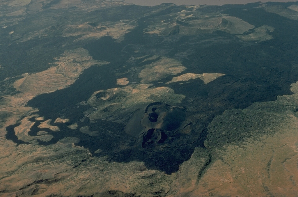 The Barrier volcano separates Lake Turkana from the Suguta Trough to the south, the site of a former lake.  The volcano is comprised of four overlapping shield volcanoes.  This view looks down the north flank of the volcano with Lake Turkana at the upper right.  Holocene fissure-related scoria cones and lava flows, including the historically active Teleki's and Andrew's cones (lower center), dot the volcano's southern and northern flanks.  Historical eruptions have produced explosive activity and lava flows during the 19th and 20th centuries. Copyrighted photo by Katia and Maurice Krafft, 1978.