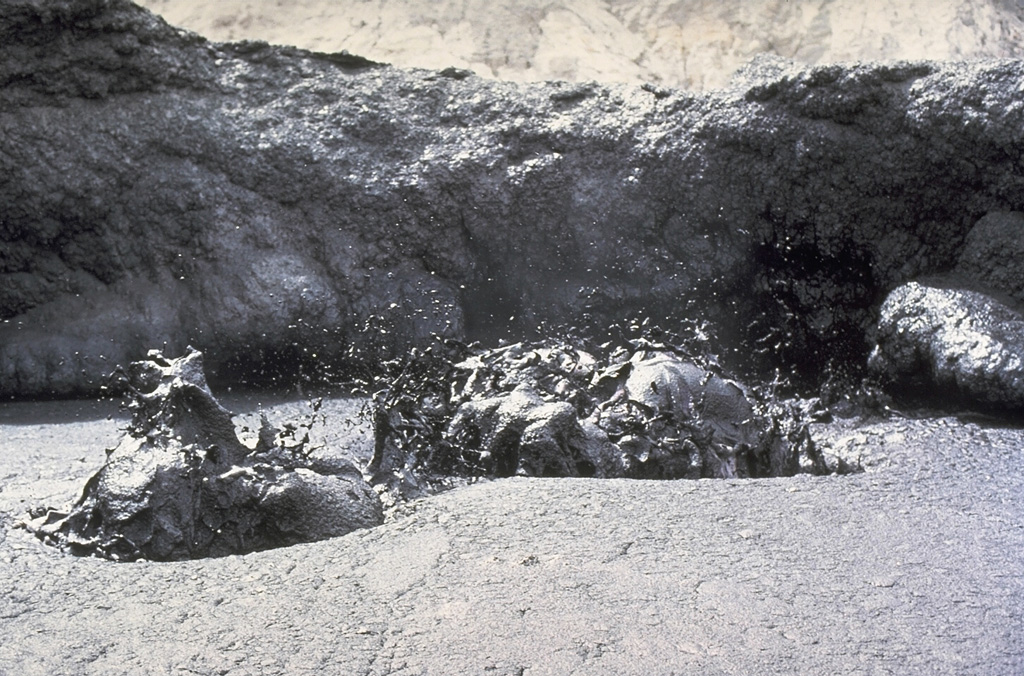 Liquid black lava is ejected from a lava lake on the crater floor of Ol Doinyo Lengai volcano in Tanzania in June 1988.  The relatively low-temperature carbonatitic lava (sodium carbonate) is black during daylight hours and is incandescent only at night.  Temperatures of 495-544 degress Centigrade were measured during a June 1988 expedition.  Slow extrusion of lava flows on the floor of the crater began in 1983. Copyrighted photo by Katia and Maurice Krafft, 1988.