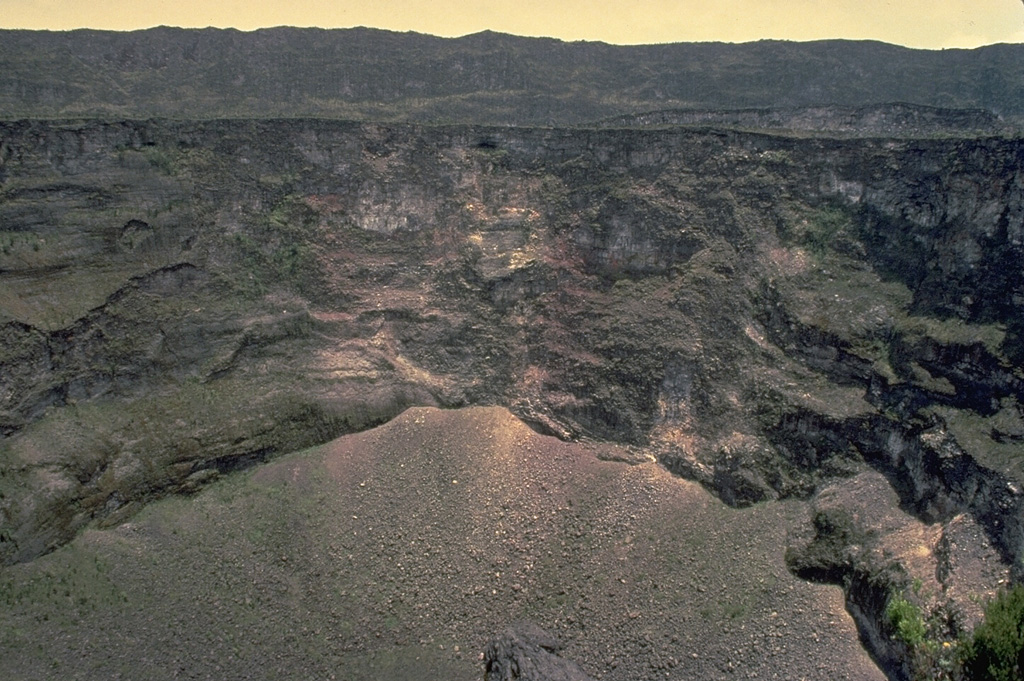 This February 1980 photo shows the wall of a pit crater within the summit caldera of Nyamuragira volcano.  The rim of the 2 x 2.3 km caldera appears in the distance.  Many changes to the morphology of the caldera floor have occurred as a result of the frequent historical eruptions of Nyamuragira since the mid-19th century. Copyrighted photo by Katia and Maurice Krafft, 1980.