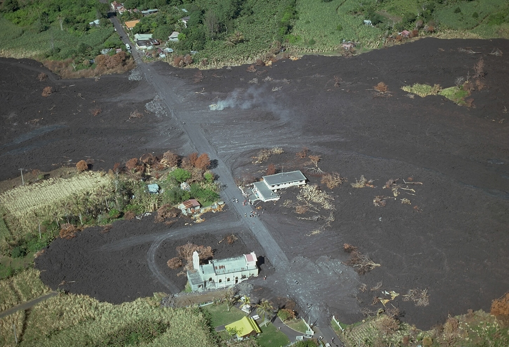 A lava flow that originated from a vent at 700-m altitude on the outer NE flank of Piton de la Fournaise volcano on 9 April 1977, cut the principal road around Réunion Island and destroyed 12 houses in the village of Piton Ste Rose.  The flow traveled 6 km before reaching the sea.  About 2500 people were evacuated from the town.  A new fissure opened up at 600-m altitude on the 9th.  It fed a lava flow that burned more than 20 more houses before the eruption ended on 16 April. Copyrighted photo by Katia and Maurice Krafft, 1977.