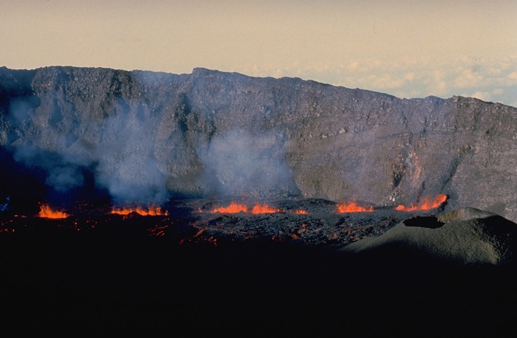 Lava fountains rise above a fissure vent on the floor of the caldera of Piton de la Fournaise volcano on Réunion Island in September 1985.  This eruptive phase occurred from vents at 2200-m altitude on the east flank of Dolomieu crater, the central crater of Piton de la Fournaise, near the beginning of an eruption that lasted from June 1985 until December 1988.  Fissures both within the caldera and on its outer flanks were active during this eruption. Copyrighted photo by Roland Benard, 1985 (courtesy of Katia and Maurice Krafft).
