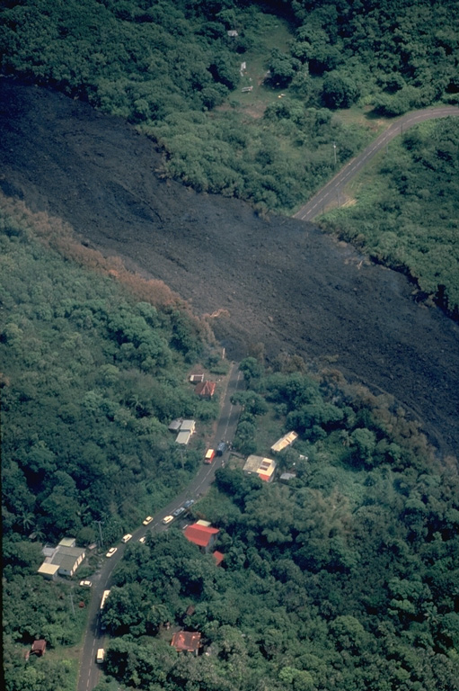 A lava flow from a vent that opened on 20 March 1986 at 1000-m altitude on the outer SE flank of Piton de la Fournaise cut a road and destroyed 8 houses, leaving 51 people homeless.  This photo was taken two days later on 22 March.  This lava flow was produced during a long-term eruption that took place from June 1985 to December 1988 from vents both within and outside the caldera. Copyrighted photo by Katia and Maurice Krafft, 1986.