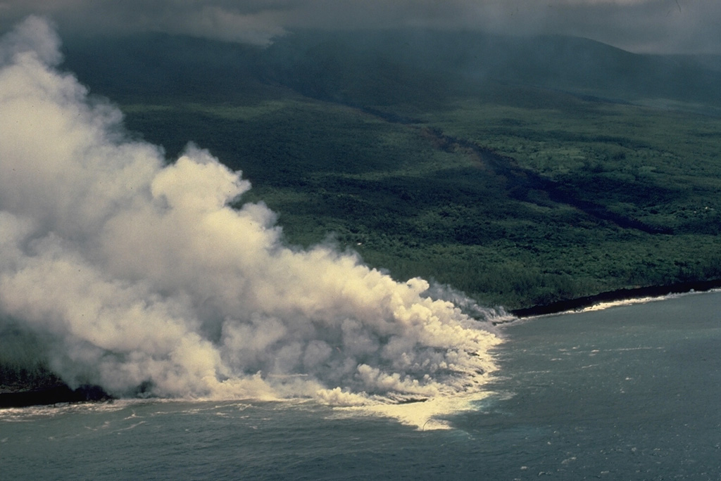 Steam clouds pour from a lava flow entering the Indian Ocean on the SE flank of Piton de la Fournaise volcano in April 1986.  The flow originated from a fissure near the coast that opened on March 23.  Another SE-flank fissure began on March 20 at 1000-m altitude near Piton Takamaka and produced a lava flow that diverged around the Piton Takamaka cone.  The northern lobe traveled more than 4 km to the sea, destroying 8 houses, while the southern lobe stopped only 250 m from the ocean. Copyrighted photo by Katia and Maurice Krafft, 1986.