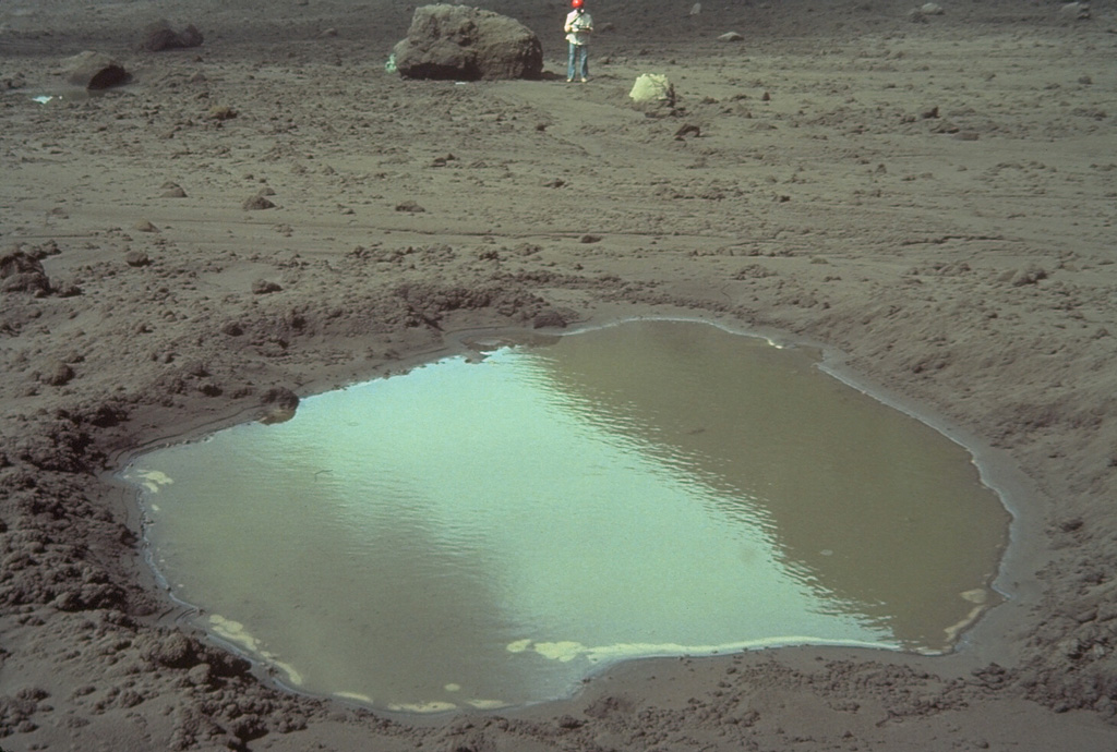This 4-m-wide, water-filled impact crater was formed when the block in background, with volcanologist Ian Nairn providing scale, was ejected during an eruption from White Island in New Zealand in late March 1977. The block, composed of pre-existing crater wall rock, bounced to form the impact crater, and then slid to its present location, 250 m from the source vent. Photo by Bruce Houghton, 1977 (Wairakei Research Center).