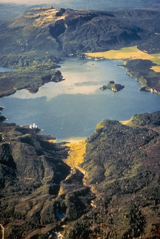 The flat-topped Tarawera lava dome complex at the top of the photo to the NE is one of two large dome complexes forming the Okataina Volcanic Centre at the N end of the Taupo Volcanic Zone. An eruptive fissure that cuts the dome complex and extends across Lake Rotomahana to the foreground was the source of a major eruption in 1886. The Tarawera complex and the Haroharo complex off the photo to the left were both sources of major explosive eruptions during the Pleistocene and Holocene that produced large ignimbrite sheets. Photo by Lloyd Homer, courtesy of Bruce Houghton (Wairakei Research Center).