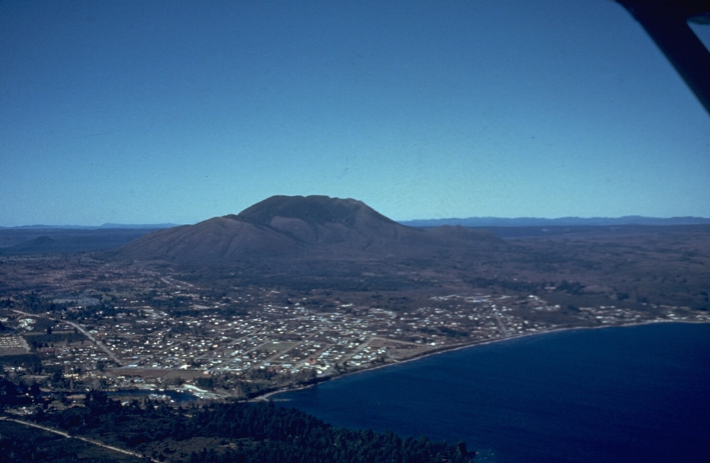 An aerial view shows the E margin of Lake Taupo with Taupo City on its shore. The 35-km-wide caldera is not topographically prominent but has been the source of powerful rhyolitic eruptions from the late Pleistocene throughout the Holocene. The 35,000-year-old Tauhara lava dome forms the peak in the background. Photo by Jim Healy (New Zealand Geological Survey).