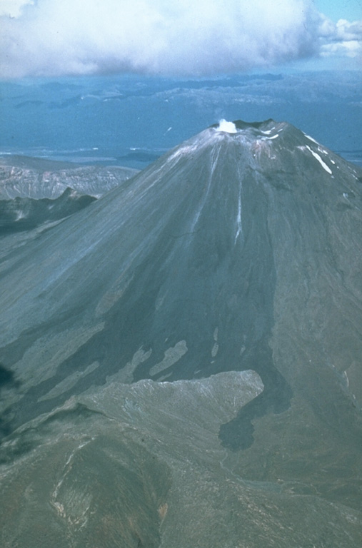 The black lava flows extending from the summit of Ngauruhoe volcano to its flanks erupted in 1954. An eruption that began with explosive activity on 13 May 1954, was followed on 4 June by the emission of lava flows that traveled down the NW flank until 26 September. Explosive activity, which constructed a scoria cone in the summit crater, continued until March 1955; incandescent lava was present in the crater until June. Photo by Jim Cole (University of Canterbury).