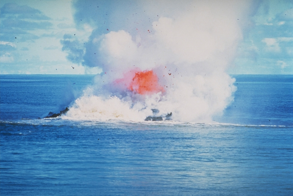 Incandescent rock and steam rise above the sea at Kavachi volcano in the Solomon Islands. By the time of this 30 June 1978 photo the vent of the submarine volcano had reached the sea surface. Dark extruded lava can be seen through the steam, with the plume rising a few thousand meters into the air. There was no sign of the submarine volcano on 20 June but the following day an eruption was observed. By the 22nd there was a 30-50 m wide island erupting incandescent lava. Photo by W.G. Muller, 1978 (Barrier Reef Cruises, Queensland, Australia; courtesy of D. Tuni).