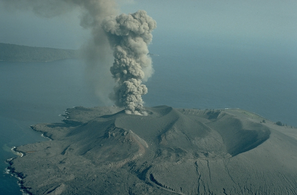 An ash-rich eruption column rises above the 1978 crater of Anak Krakatau on 12 September 1979. Explosive activity began in mid-July 1979 and continued until November. A lava flow was emplaced during 18-21 September. Verlaten Island, part of the rim of Krakatau caldera, appears in the background to the NW. Copyrighted photo by Katia and Maurice Krafft, 1979 (published in SEAN Bulletin, 1979).