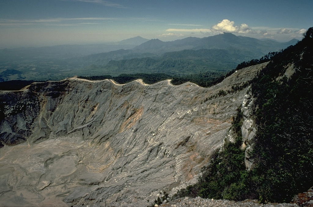 Nine partially overlapping craters form an elliptical depression at the summit of Tangkubanparahu volcano, north of the city of Bandung.  Numerous small phreatic eruptions have been recorded since the early 19th century.  Tangkubanparahu is one the most visited tourist desitinations near the city of Bandung, Indonesia's third largest city. Copyrighted photo by Katia and Maurice Krafft, 1971.