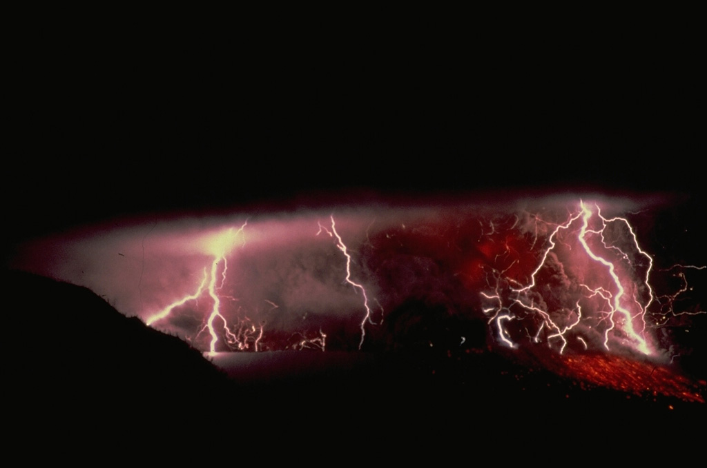 Lightning often is associated with ash-laden eruption plumes.  This view is of a September 1982 eruption of Galunggung volcano in Indonesia.  Incandescent ejecta, mostly obscured by an ash column above the vent, can be seen on the flanks of the cone at the lower right. Copyrighted photo by Katia and Maurice Krafft, 1982.