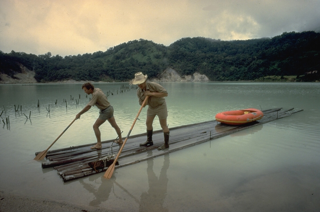 Volcanologist Maurice Krafft (right) and a companion maneuver a raft to conduct water sampling at Talagabodas ("White Lake").  The 400-500 m wide lake is sulfur saturated, and has elevated temperatures.  Fumaroles and mud pots are found on its margins. Copyrighted photo by Katia and Maurice Krafft, 1971.