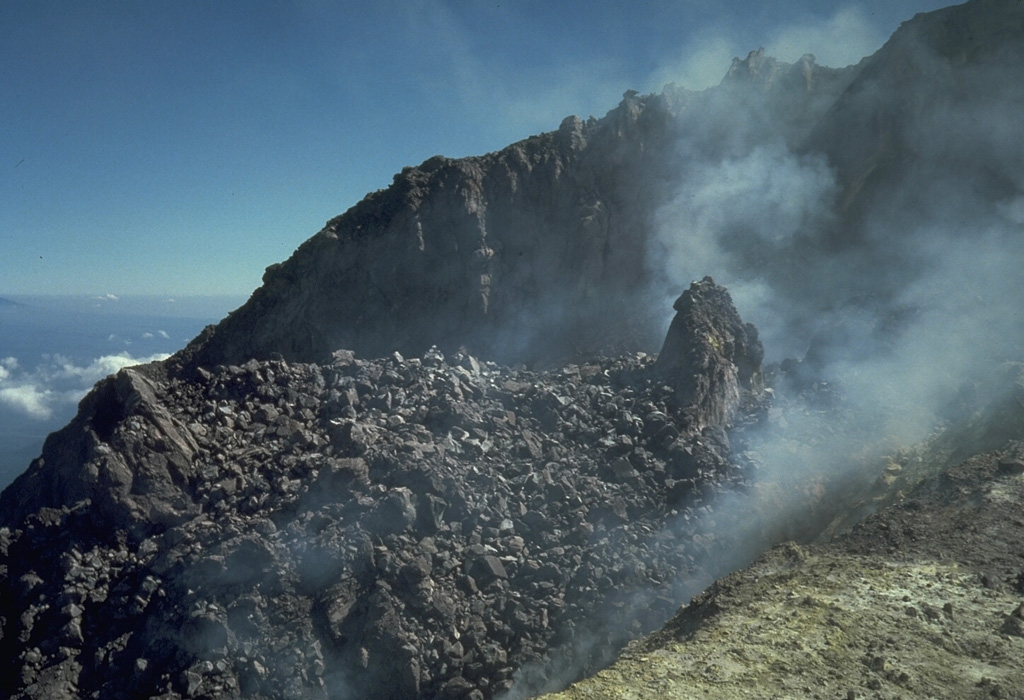 A lava dome that was produced during 1972-1985 lies within the summit crater of Merapi volcano in central Java. A small spine appears on the right in this 4 July 1986 photo, which was taken during a period of inactivity prior to destruction of the dome on 10 October 1986. Historical eruptions have been characterized by repeated growth and collapse of the summit lava domes, periodically producing pyroclastic flows that have impacted communities on the western and southern flanks. Photo by Tom Casadevall, 1986 (U.S. Geological Survey).