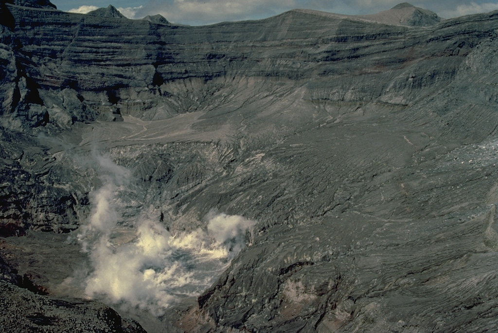 Fumaroles rise above the crater following the 1990 eruption, which removed much of the crater lake of Kelud volcano, leaving a small 150-m-wide pit crater partially filled by a small lake. Copyrighted photo by Katia and Maurice Krafft, 1990.