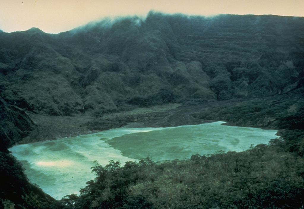 Kelud volcano has been notorious for the repeated ejection of crater lake water during eruptions, producing devastating lahars. A series of tunnels and shafts were constructed in the 1920s to lower the lake level and reduce the hazards of eruptions. The initial tunnels lowered the lake level 50 m, but the 1951 eruption deepened the crater by 70 m, leaving 50 million m3 of water. Following another devastating eruption in 1966, lower outlet tunnels were constructed, and prior to the 1990 eruption the lake contained only 1 million m3 of water. Photo by John Dvorak, 1980 (U.S. Geological Survey).