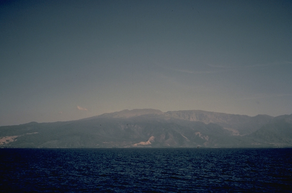 Seen from the sea, Tambora volcano presents a broad, flat profile.  The volcano, forming the 60-km-wide Sanggar Peninsula, is truncated by a 6-km-wide caldera.  One of the world's largest eruptions during the last 10,000 years produced the present-day caldera in 1815. Copyrighted photo by Katia and Maurice Krafft, 1971.