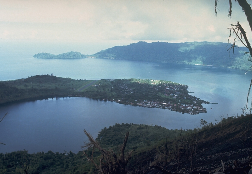 The arcuate islands of Banda Neira and Lonthor, seen here looking E from the summit of Indonesia's Banda Api volcano, are remnants of two largely-submarine calderas that preceded the construction of the Banda Api stratovolcano. The outer caldera has a diameter of 7 km and the nested inner caldera is 3 km wide. Neira, the largest town in the Banda Islands, occupies the southern tip of Banda Neira Island. Photo courtesy Tom Casadevall, 1988 (U.S. Geological Survey).