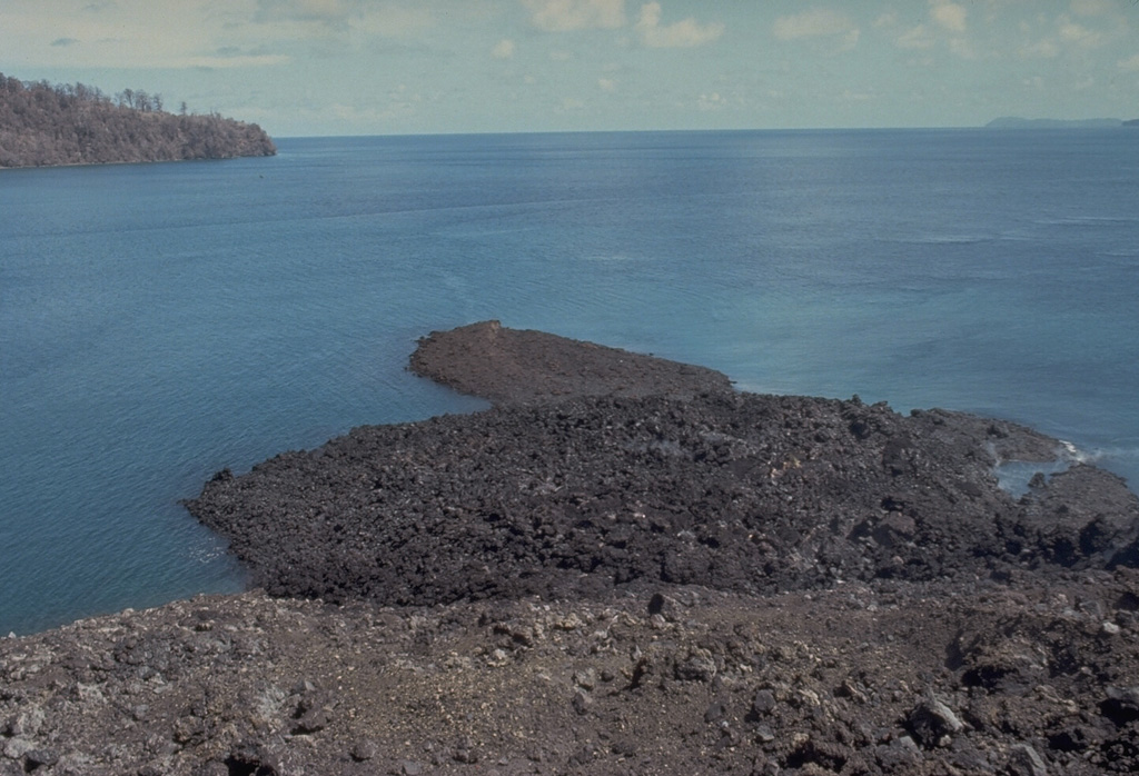 A small lava flow from a vent low on the south flank of Gunung Api flowed into the sea, forming a narrow peninsula.  The May 9, 1988 lava flow was erupted from a 100-m-long fissure that produced a tuff cone over the vent.  Minor submarine activity occurred at the lower end of the fissure.  The western tip of Bantur Island appears in the background. Photo by Tom Casadevall, 1988 (U.S. Geological Survey).