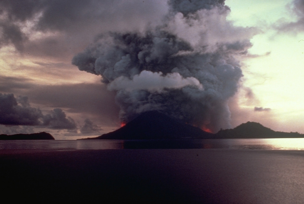 Vigorous explosive eruptions continue from Banda Api volcano at dusk on May 9, 1988.  Incandescent lava fountains rise above vents on the northern and southern flanks and the eruption column reaches a height of about 5 km.  Activity began at about 6:30 that morning from an eruptive fissure that cut across the volcano.  Neira Island is at the right and the western tip of Lonthur Island at the left in this view from the ENE.   Photo by Shoji and Taeko Ozawa, 1988, courtesy Tom Casadevall (U.S. Geological Survey).