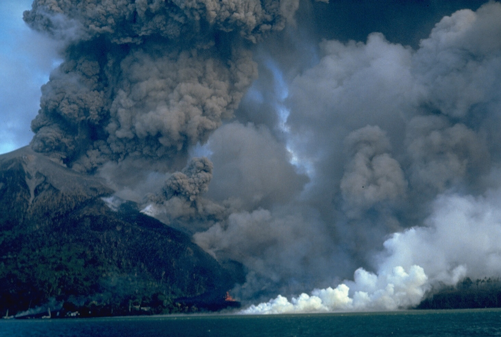 An eruption of Indonesia's Banda Api volcano, seen here on 10 May 1988, took place from a N-SSW-trending fissure that cut across the island. Both explosive activity and lava effusion occurred along the fissure. Billowing, ash-rich eruption plumes rose from vents along the N end of the fissure. Minor lava fountaining can be seen here at the lower-center, near the N coast. White steam marks the entry of the lava flow into the sea after overrunning two villages. Photo by Willem Rohi, 1988 (Volcanological Survey of Indonesia).