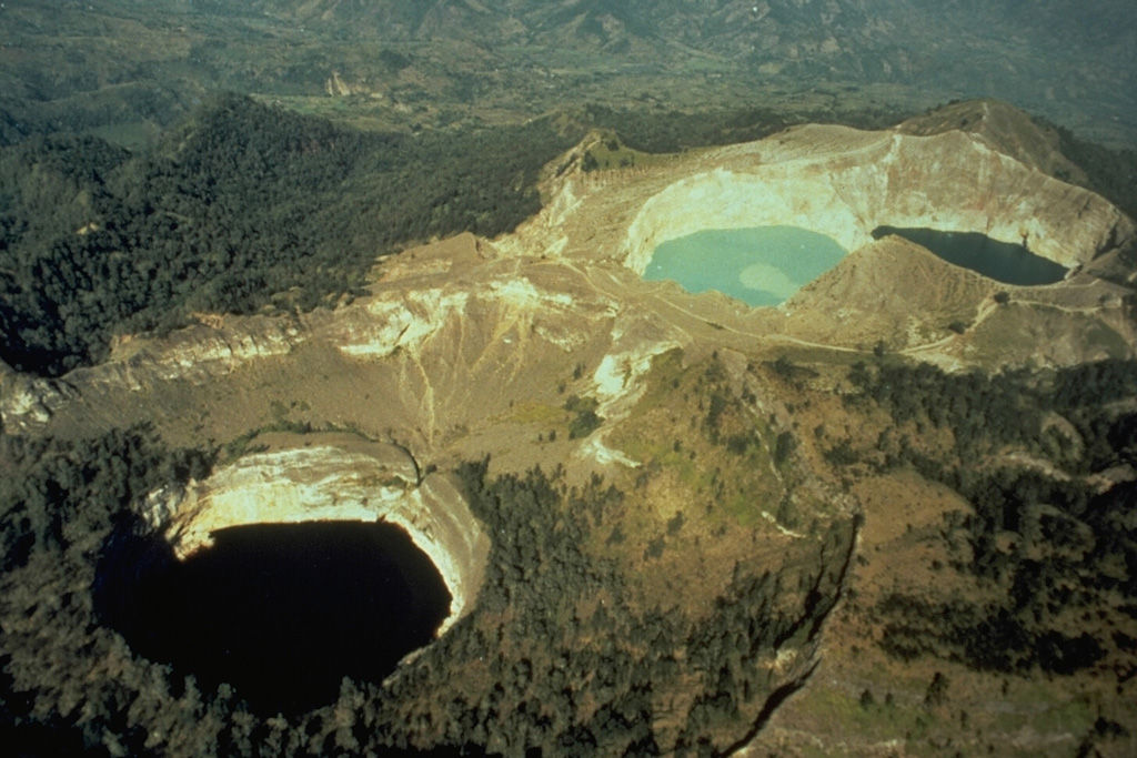 Kelimutu, a small volcano on Flores Island, is noted for its three crater lakes of different colors. This aerial view from the SW shows Tiwu Ata Mbupu at the lower left, and the two craters of Tiwu Nua Muri Kooh Taiand Tiwu and Ata Polo at the upper right. Water color varies periodically with variations of blue, green, and red. Phreatic eruptions have occurred from the middle lake in historical time. Photo by Tom Casadevall (U.S. Geological Survey).