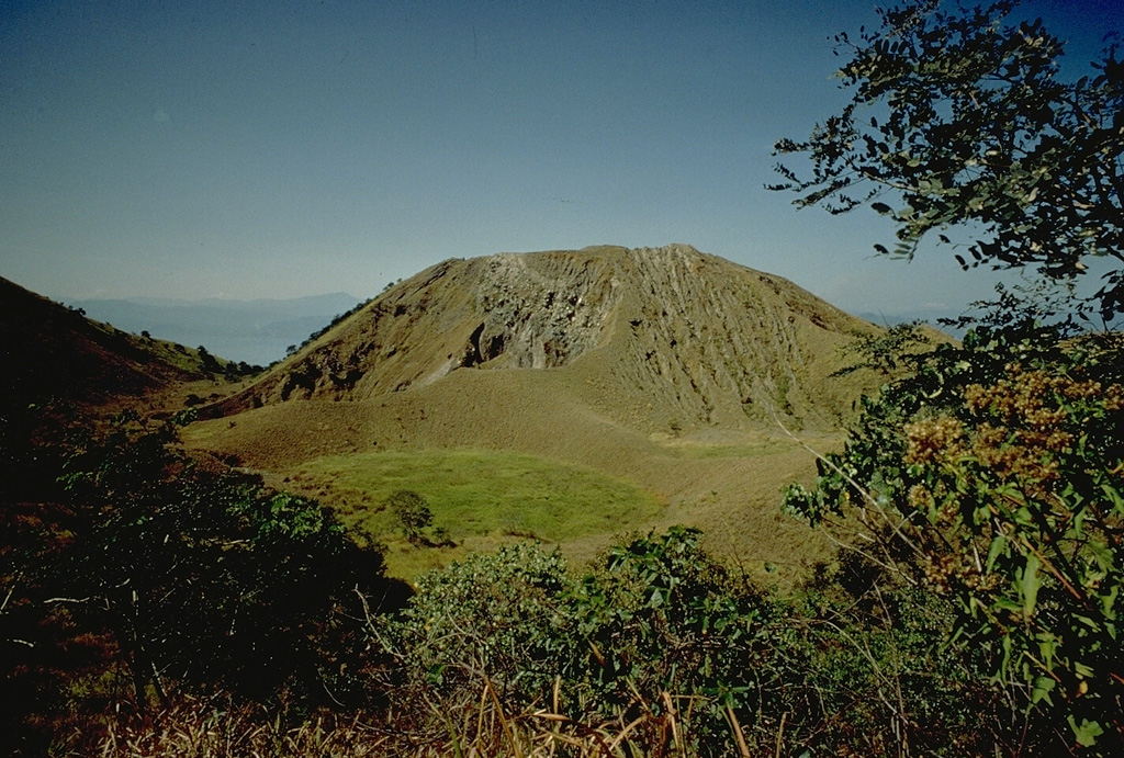 The 8-km-wide island of Paluweh, north of central Flores Island, contains multiple summit craters and lava domes, one of which is seen in this 1971 photo.  A chain of flank vents forms a NW-SE line on the NW flank. No eruptions of Paluweh were recorded between its first historical eruption in the 17th century and a major eruption in 1928.  Occasional eruptions since then have produced explosive activity, sometimes accompanied by lava dome growth. Copyrighted photo by Katia and Maurice Krafft, 1971.