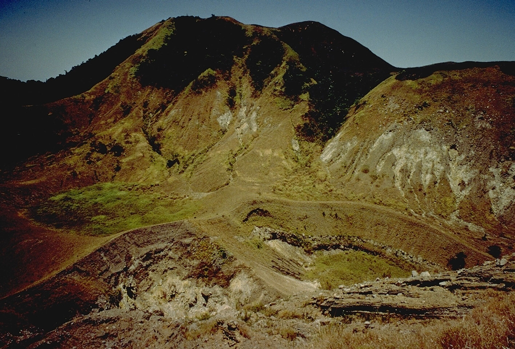 The craters in the foreground are two of many found at the summit of Paluweh (Rokatenda) volcano.  The southern part of the 8-km-wide island has been truncated by collapse.  More than a half dozen eruptions have occurred at Paluweh volcano in the 20th century. Copyrighted photo by Katia and Maurice Krafft, 1971.