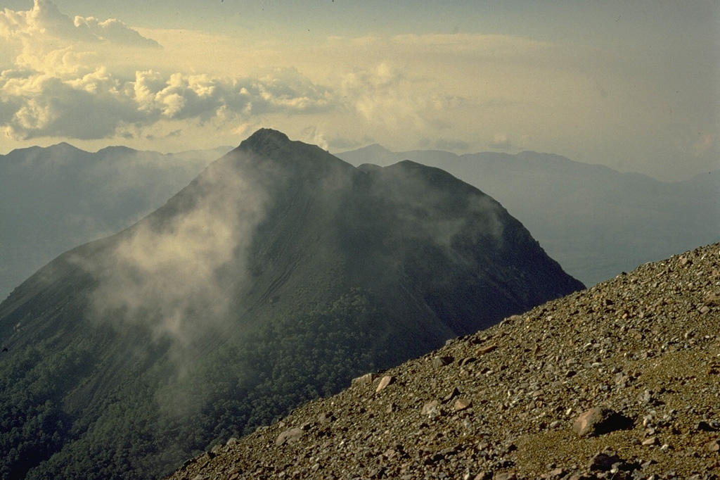 The summit of the sharp-peaked 1584-m Lewotobi Lakilaki is seen from its twin volcano located only 2 km to the SE, Lewotobi Perempuan.  Lewotobi Lakilaki is the most active volcano on Flores Island, with frequent explosive eruptions in the 19th and 20th centuries.  A 1932-33 eruption was accompanied by lava dome formation and pyroclastic flows. Copyrighted photo by Katia and Maurice Krafft, 1971.