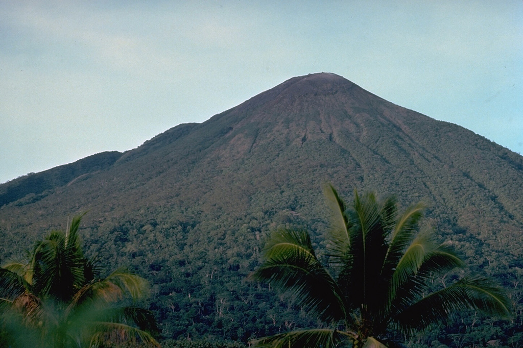 Gamalama volcano (also known as the Peak of Ternate), one of the most active volcanoes of Indonesia, forms Ternate Island, at the north end of a chain of islands off the west coast of Halmahera.  The volcanic island was a central focus of the Portuguese and Dutch spice trade for several centuries.  Three cones, progressively younger to the north, form its summit.  Frequent eruptions have occurred since the 16th century, mostly from the summit vent, although flank eruptions have occurred on four occasions, most recently in 1962-63. Copyrighted photo by Katia and Maurice Krafft, 1976.