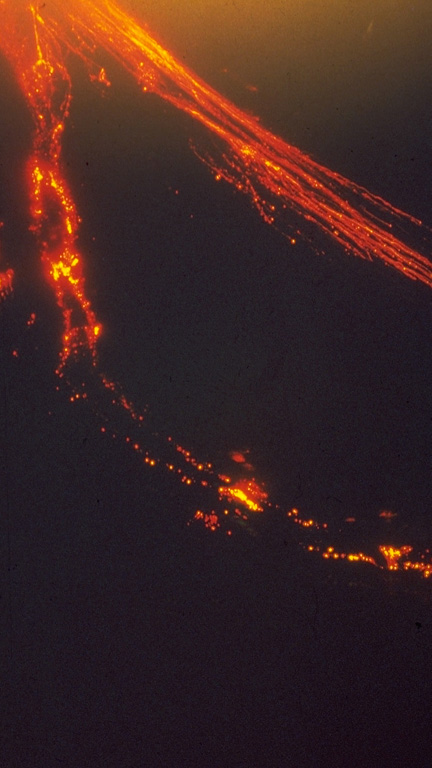 An incandescent lava flow descends the SW flank of Mayon (left). This 18 September 1984 time-lapse photo taken from near Masarawag also shows incandescent blocks to the right that were ejected by explosive eruptions and are cascading down the south flank. Photo by Emmanuel Ramos, 1984 (Philippine Institute of Volcanology and Seismology).