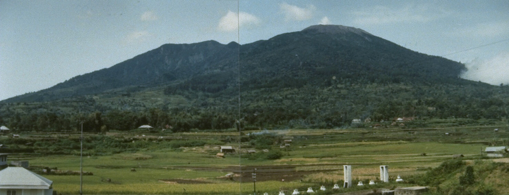 The composite volcano Marapi rises 2,000 m above the Padang Highlands of central Sumatra in this view from Padankuda. Marapi has frequent historical eruptions from the broad E-W-trending line of summit craters. Photo by Agus Solihin, 1991 (Volcanological Survey of Indonesia).