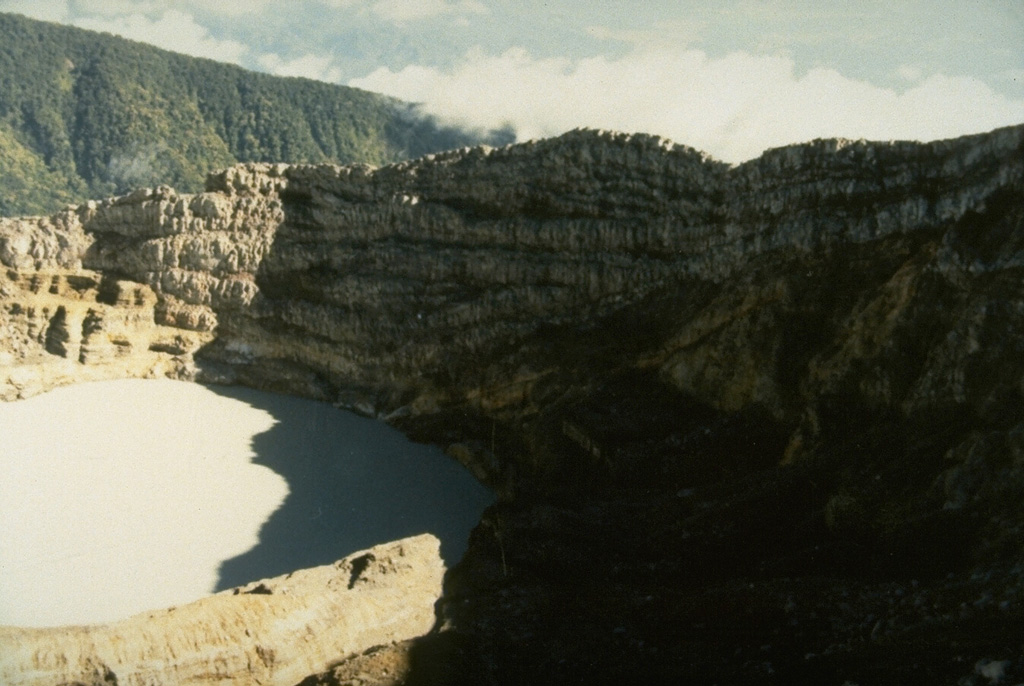 The crater wall above the historically active crater lake within Kawah Merapi crater at the summit of Dempo volcano shows a series of alternating lava flows and pyroclastic deposits. Photo by Ruska Hadian, 1989 (Volcanological Survey of Indonesia).