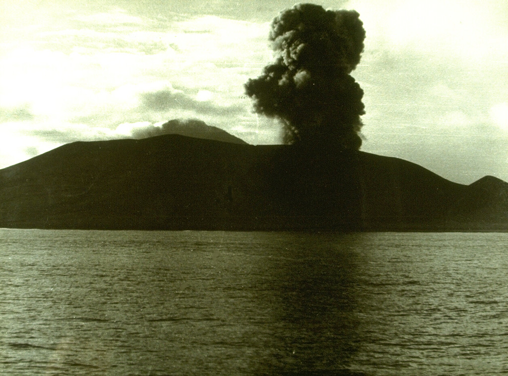 An eruption plume rises above Anak Krakatau on 13 February 1960. Explosive activity at Anak Krakatau was almost continuous from December 1959 until 1963. The construction of a new cone displaced the crater lake. A lava flow that reached the sea was emplaced sometime between 1960 and 1963. Photo courtesy Volcanological Survey of Indonesia, 1960.