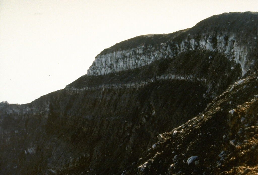 A thick lava flow is exposed by the summit crater of Gede volcano. The 1-km-wide summit crater of Gede has migrated to the NNW over time and contains several smaller craters. Photo by Sunaman (Volcanological Survey of Indonesia).