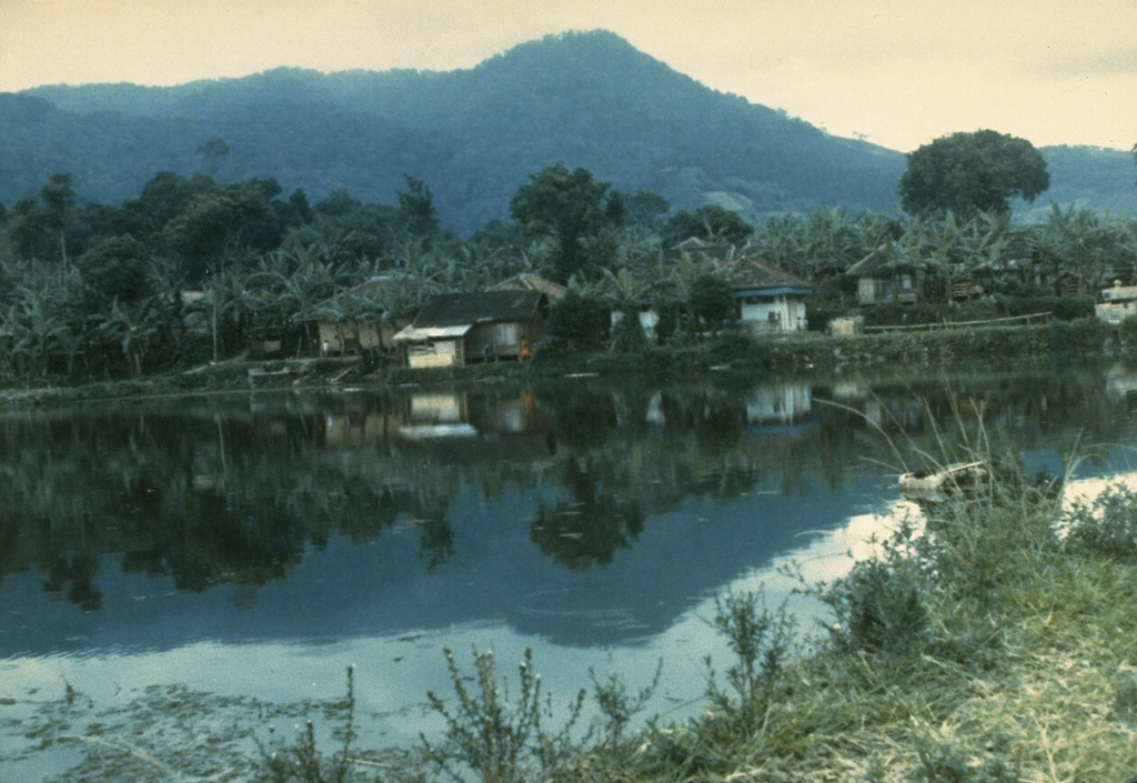 The older NW portion of Guntur volcano rises above a small lake at the Cipanas hot spring resort SE of the volcano. Guntur and neighboring volcanoes surrounding the plain of Garut were some of the oldest tourist destinations in Java.  Photo by J. Matehelumual, 1986 (Volcanological Survey of Indonesia).